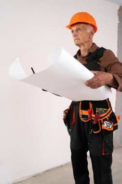 Üst düzey emekli mimar odaların planlarını tutuyor. Belgelerle çalışan inşaat mühendisi. İnşaat ve konut yenileme konsepti