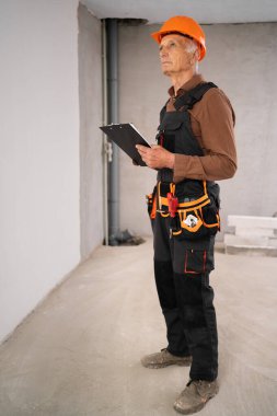 İnşaat alanında eski erkek müteahhit ve pano inşaatçıları. iş, inşaat ve evrak işleri kavramı