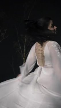 Beyaz elbiseli kız gece sahnede dans ediyor. Boşluğu kopyala