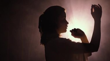 Gizemli bir gece. Beyaz elbiseli bir kızın silueti ellerini aya doğru incelikle hareket ettiriyor. Merhamet ve şefkat kavramı.