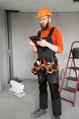 İnşaat işçisi ya da yeni evde tabletli inşaatçı. meslek, inşaat ve inşaat kavramı