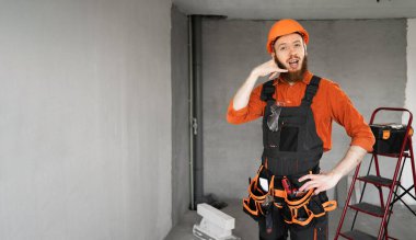 Koruyucu miğferli ve tulumlu sakallı müteahhit, 