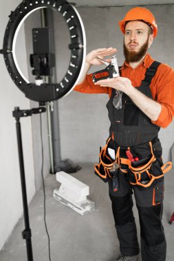 İnşaatçı blogcu kamerada zımba tabancasını göstermekten ya da tamir etmekten bahsediyor. daire yenileme konsepti