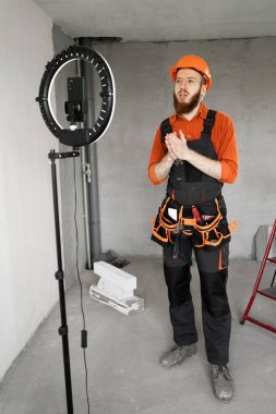 Bir inşaat işçisi ya da tamirci, video blogunu yöneten bir akıllı telefondan canlı yayın yapıyor. Boşluğu kopyala