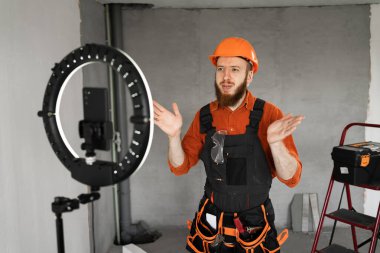 Erkek müteahhit blogcu akıllı telefon kamerasında tamirden bahsediyor. Bloglama ve apartman yenileme kavramı