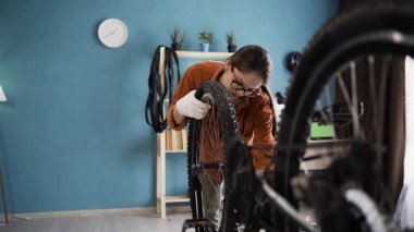 Evde tadilattan sonra tekerlek montajı yapan genç bir kadın. Boşluğu kopyala