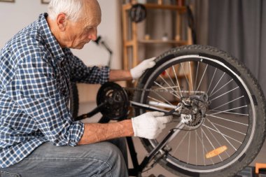 Evde ya da atölyede bisiklet tamir eden emekli adam, kopyalama alanı