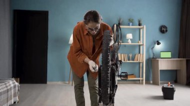 Evde bisiklet tamir eden bir kadın, içeride ingiliz anahtarıyla tekerleği tamir ediyor. Bisiklet onarımı ve bakım konsepti