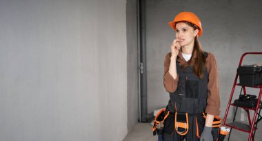 Stres ya da krizi düşündüğü için tırnaklarını yiyen üzgün kadın müteahhit. Şantiyede panik ya da korku duyan yorgun bir tamirci kadın. Boşluğu kopyala