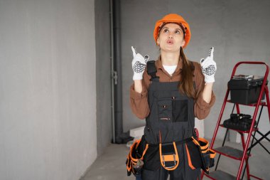 İyi bir fikri olan bir kadın müteahhit. Tulumlu ve şapkalı tamirci kadın inşaat alanında işe başlamak için plan yapıyor. Pankart. Boşluğu kopyala