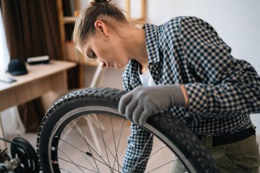 Dişi bisiklet tamircisi bisikleti söker ve tamir eder. Bakım konsepti. Boşluğu kopyala