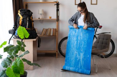 Dişi yürüyüşçü sırt çantasıyla seyahat etmeye hazırlanıyor. İç kısımdaki dağlarda yürümek için paspas taşıyor. Kamp ve yürüyüş ekipmanları. Boşluğu kopyala