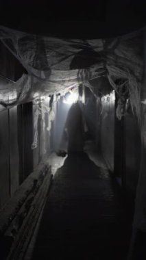 Beyaz çarşaflı hayalet geceleri terk edilmiş binaların ürpertici koridorlarında yürüyor. Doğaüstü korku filmi ve perili yer kavramı. Dikey video