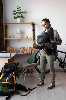 Dişi sırt çantalı sırt çantası paketleyicisi, ev içi gezisi için sırt çantası hazırlıyor. Boşluğu kopyala