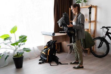 Bayan sırt çantalı sırt çantalı gezisi için evdeki oturma odasına gitti. Boşluğu kopyala