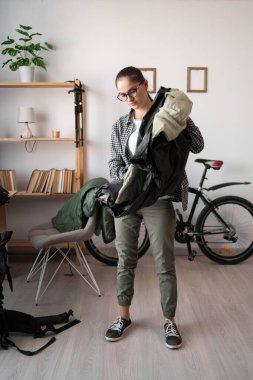 Gözlüklü, sırt çantalı, sırt çantalı ve sırt çantalı bir kadın. Evdeki çadırı için. Boşluğu kopyala