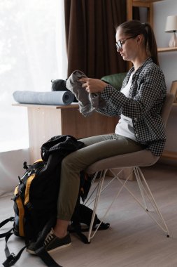 Yürüyüş için hazırlanan yürüyüşçü kadın sırt çantasıyla dağ yürüyüşüne hazırlanıyor. Boşluğu kopyala