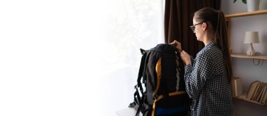 Yürüyüş için hazırlanan yürüyüşçü sırt çantasıyla eve doğru yürüyüşe çıktı. afiş, boşluğu kopyala