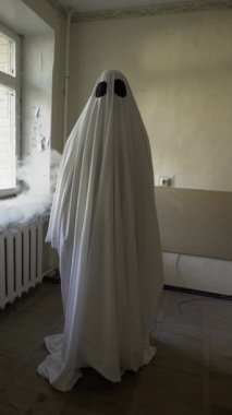 Beyaz çarşaflı cadılar bayramı hayaleti. Cadılar bayramı ürkütücü konsepti. Dikey video