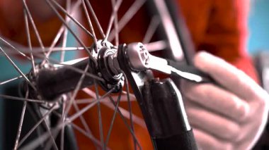 Kadın bisiklet tamircisinin yakın çekimi bir dağ bisikleti monte eder ve tekerleği tamir eder. Bakım kavramı