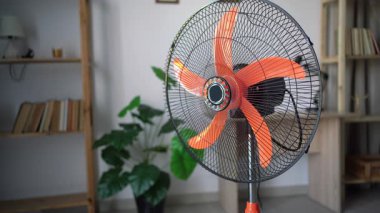 Yerdeki elektrikli vantilatörü aç. Havalandırma vantilatörü çalışıyor, evi soğutuyor. Yakın plan.