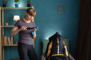 Kadın evde kamerayı test etmek için geziye çıkıyor. Modern kamera ve seyahat kavramı. Boşluğu kopyala