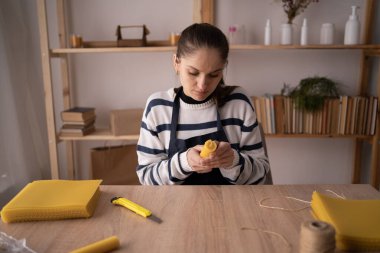 Balmumu çarşafının mumları kadının elinde. Bal peteği vakfı konsepti. Boşluğu kopyala