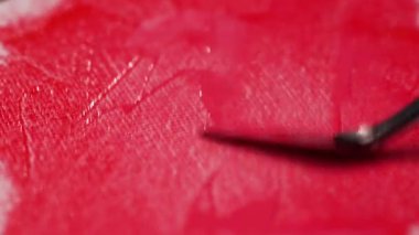 Kırmızı renkli akrilik boya uygulayan spatula kullanarak kumaş brandaya yaklaş, yaratıcılık kavramı