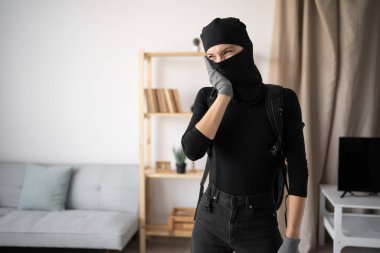 Hırsız, hırsız ve hırsız. Siyah kar maskesi ve eldiven giyen üzgün genç bir kadın birinin evine diş ağrısı çekiyor. Boşluğu kopyala