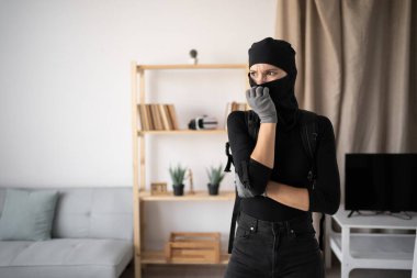 Hırsız, hırsız ve hırsız. Birinin evine siyah kar maskesi ve eldiven takan düşünceli genç bir kadın. Boşluğu kopyala