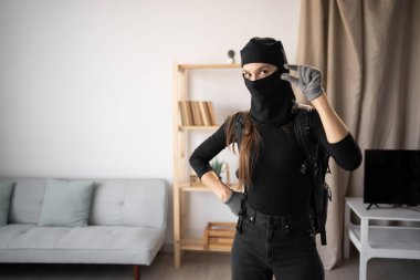 Hırsız, hırsız ve hırsız. Siyah kar maskesi takan genç bir kadın ve eldivenler birinin evine parmaklarıyla küçük bir çimdik gösteriyor. Boşluğu kopyala