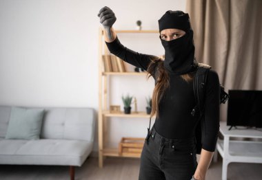 Hırsız, hırsız ve hırsız. Siyah kar maskesi takmış genç bir kadın ve eldivenler birinin evine parmak basıyor. Hoşlanmıyorum ve katılmıyorum.