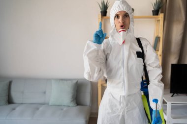 Genç kadın ilaçlamacı ya da müteahhit evde böcek kontrolü yapıyor. Boşluğu kopyala