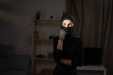 Siyah kar maskeli şapkalı düşünceli hırsız kameraya bakarken düşünüyor. Hırsızlık, suç ve soygun..