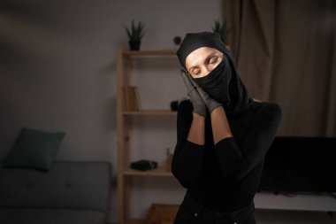 Hırsızlık kavramı. Kadın hırsız ya da siyah kar maskeli soyguncu uyku jesti yapıyor. Boşluğu kopyala