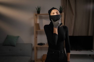 Hasta hırsız boğazını acıdan tutarken boğazı ağrıyor, hem de evi çalarken. Sağlık sorunları kavramı.