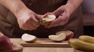 Kadın meyveli turta ya da pasta için elma soyar. Aşırı derecede yakın çekim