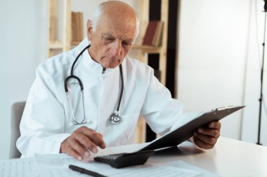 Doctor. Elderly senior doctor taking notes on a clipboard. Medicine and Healthcare. copy space