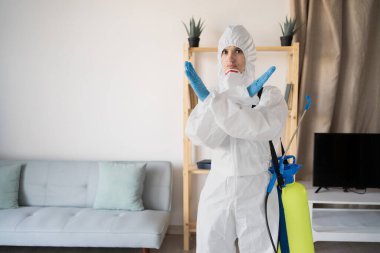 Haşere Kontrol Servisi 'nden kadın ilaçlamacı evin içinde sprey sıkma şişesiyle çalışıyor, evde iz yok. Jesti reddet. Boşluğu kopyala