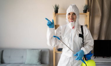 Evde çalışan haşere ilaçlama servisinden kadın ilaçlayıcı sprey şişesiyle evde mesaj için yeri işaret ediyor. Boşluğu kopyala