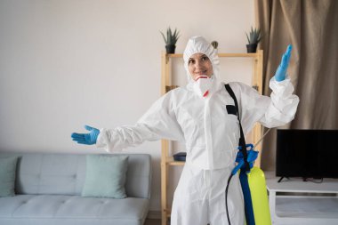 Haşere Kontrol Servisi 'nden kadın ilaçlayıcı sprey şişesiyle evin içinde çalışıyor, özür dile ve bilmiyorum, evde. Boşluğu kopyala