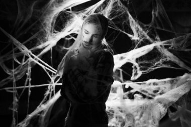 Halloween. Celebration. Silhouette of man wrapped spiderwebs on black background. copy space. black and white photo