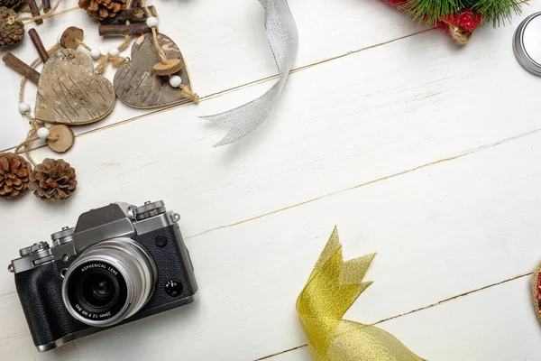 节日作文 配有照相相机和彩色圣诞装饰品 白色木制背景 有文字空间 图库照片