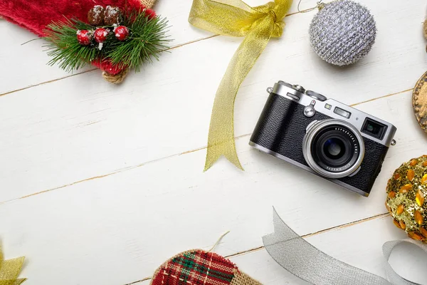 节日作文 配有照相相机和彩色圣诞装饰品 白色木制背景 有文字空间 免版税图库照片