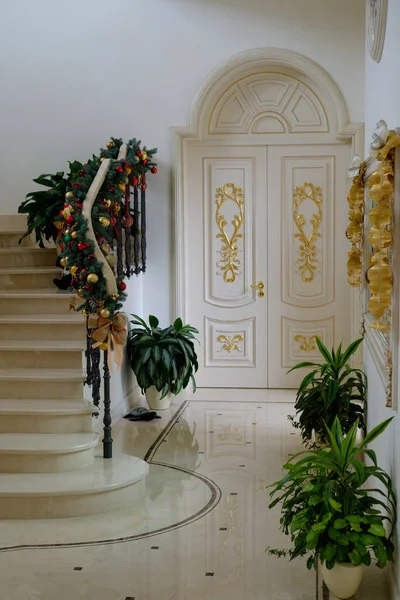 除夕夜 豪华住宅大厅里的圣诞装饰品上有大理石楼梯和地板 图库图片