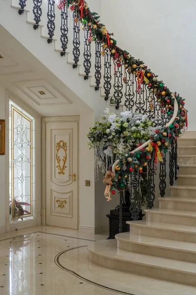 大晦日に大理石の階段と床を持つ豪華な家のホールでクリスマスの装飾 ストックフォト