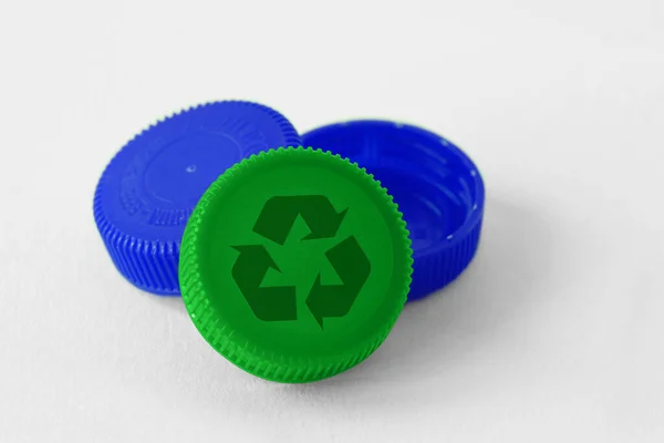 白い背景にリサイクルシンボルを持つプラスチックボトルキャップ リサイクル可能なアイテムや材料の概念 — ストック写真