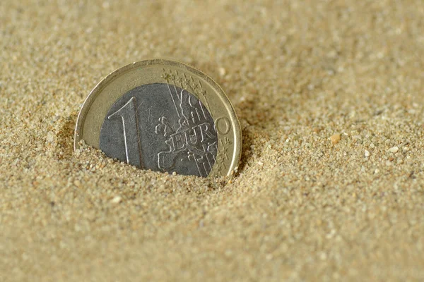 stock image Euro coin covered by sand - Concept of finance and business