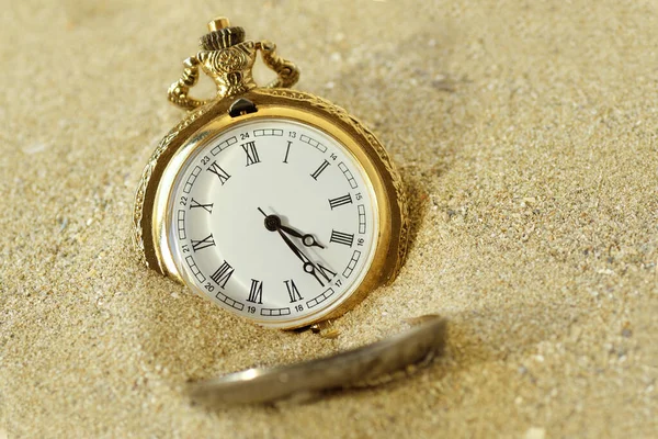 Pocket watch in the sand - Concept of time passing