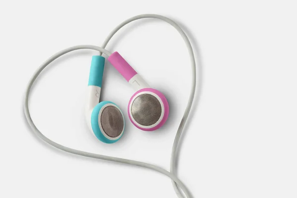 白を基調としたハート型の青とピンクのイヤフォン 男女間の愛とコミュニケーションの概念 ジェンダーコミュニケーション — ストック写真